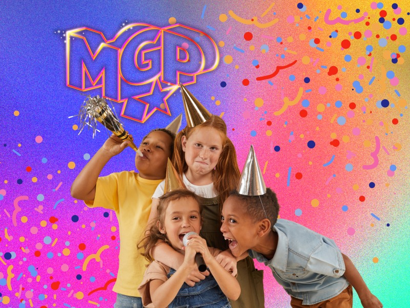 Fire børn med festhatte, truthorn og en hjemmelavet mikrofon. 