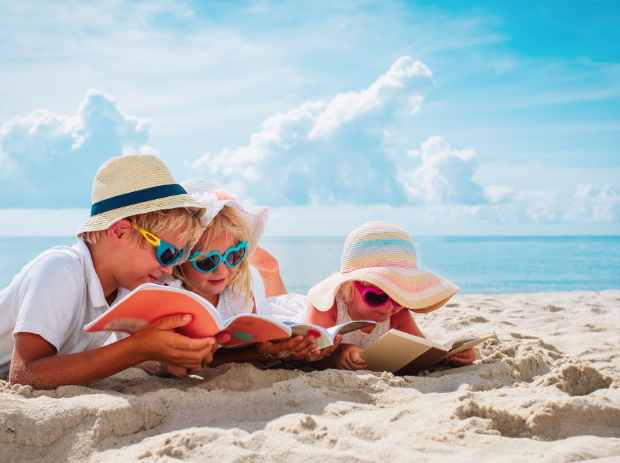 Børn læser sammen på stranden